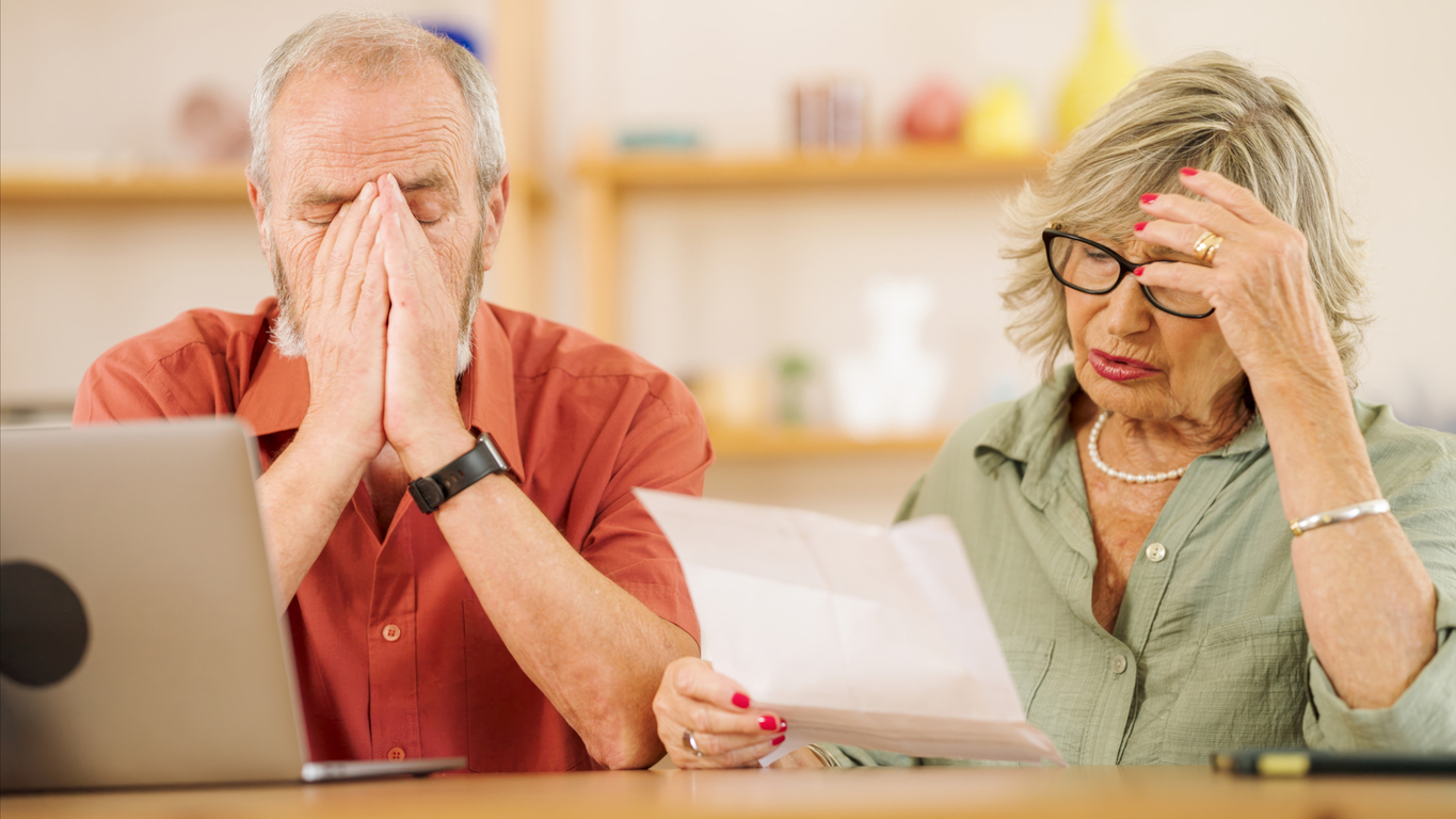 Worried homeowners reviewing their solar loan paperwork at the kitchen table