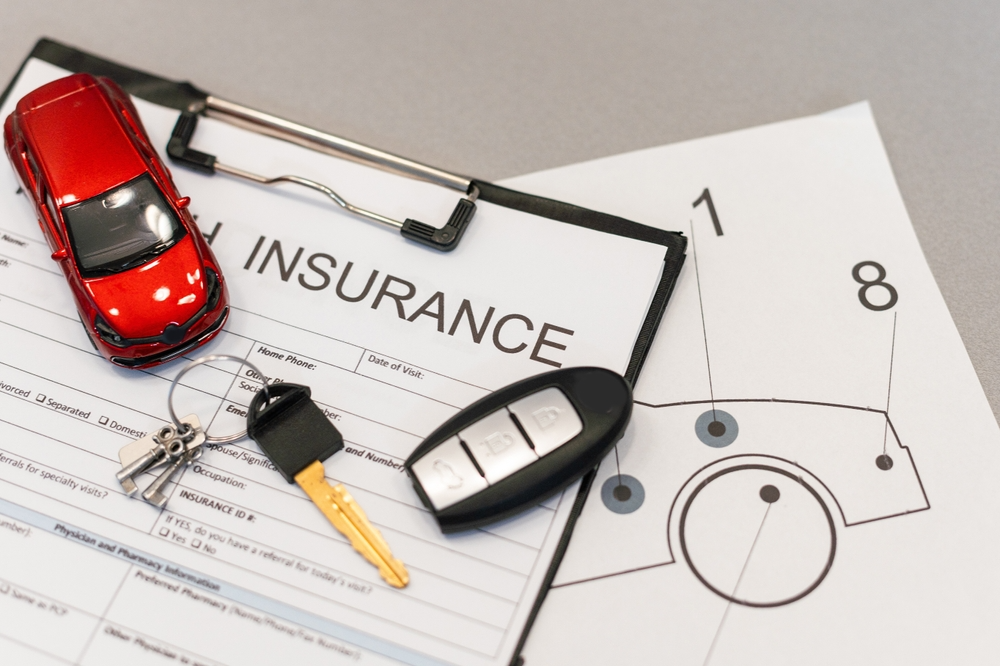 Person reviewing car insurance policy after a vehicle incident, focusing on coverage and protection details.