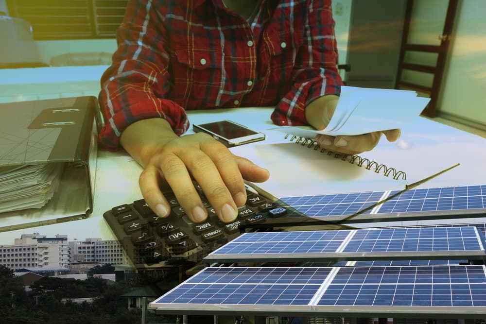 Hand with calculator. solar energy